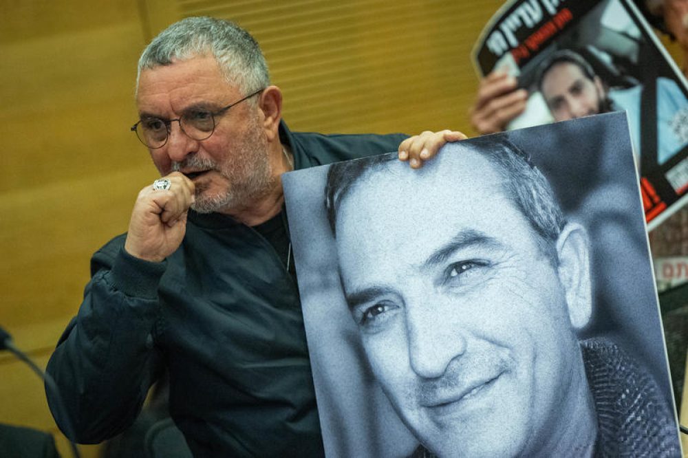 Danny Elgarat met een foto van zijn door Hamas vermoorde broer Itzhik - Foto: Yonatan Sindel/Flash90