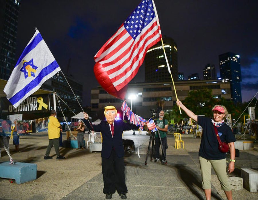Israëlische burgers met vlaggen en verkleed als Donald Trump vieren de aanstaande vrijlating van de gijzelaars in Gaza - Foto: Avshalom Sassoni/Flash90