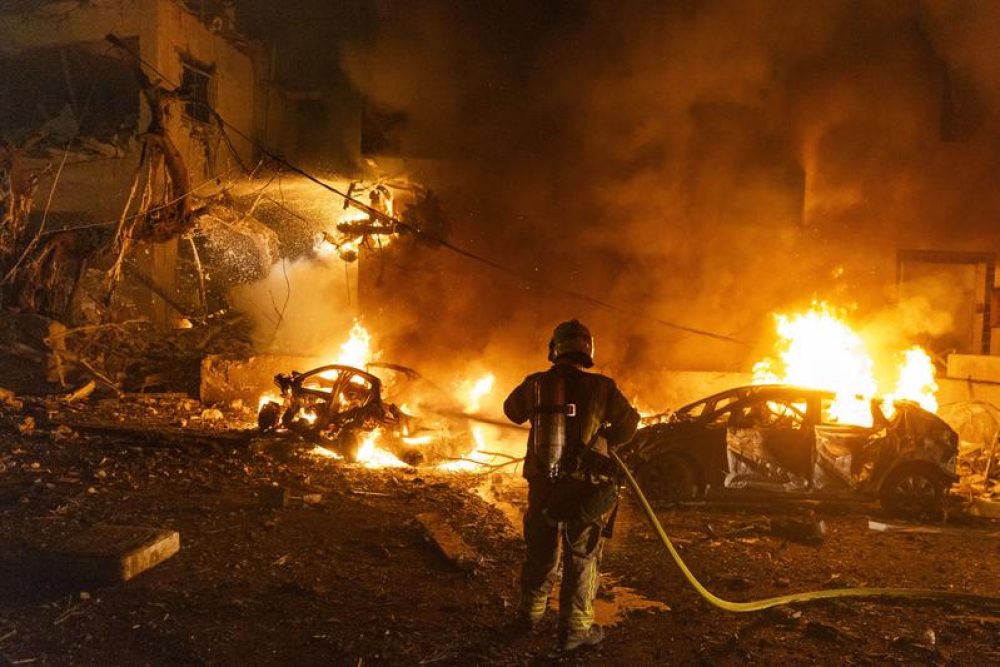 Een brandweerman bestrijdt het vuur dat is veroorzaakt door de inslag van een Iraanse ballistische raket in Tel Aviv - Foto: Chaim Goldberg/Flash90