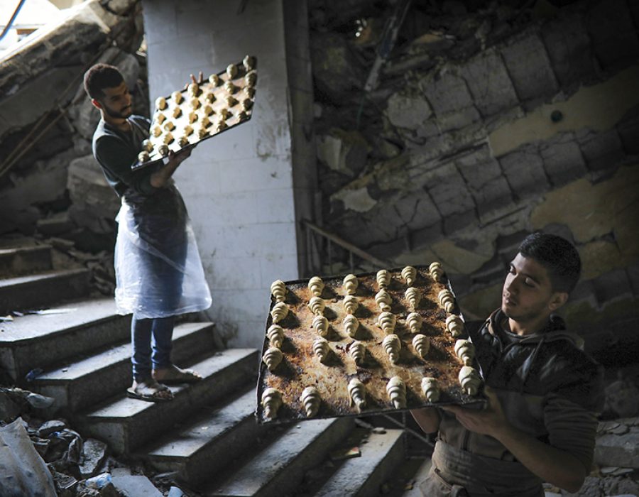 Palestijnen aan het werk in een beschadigde bakkerij in Gaza. Foto: Ali Hassan/Flash90