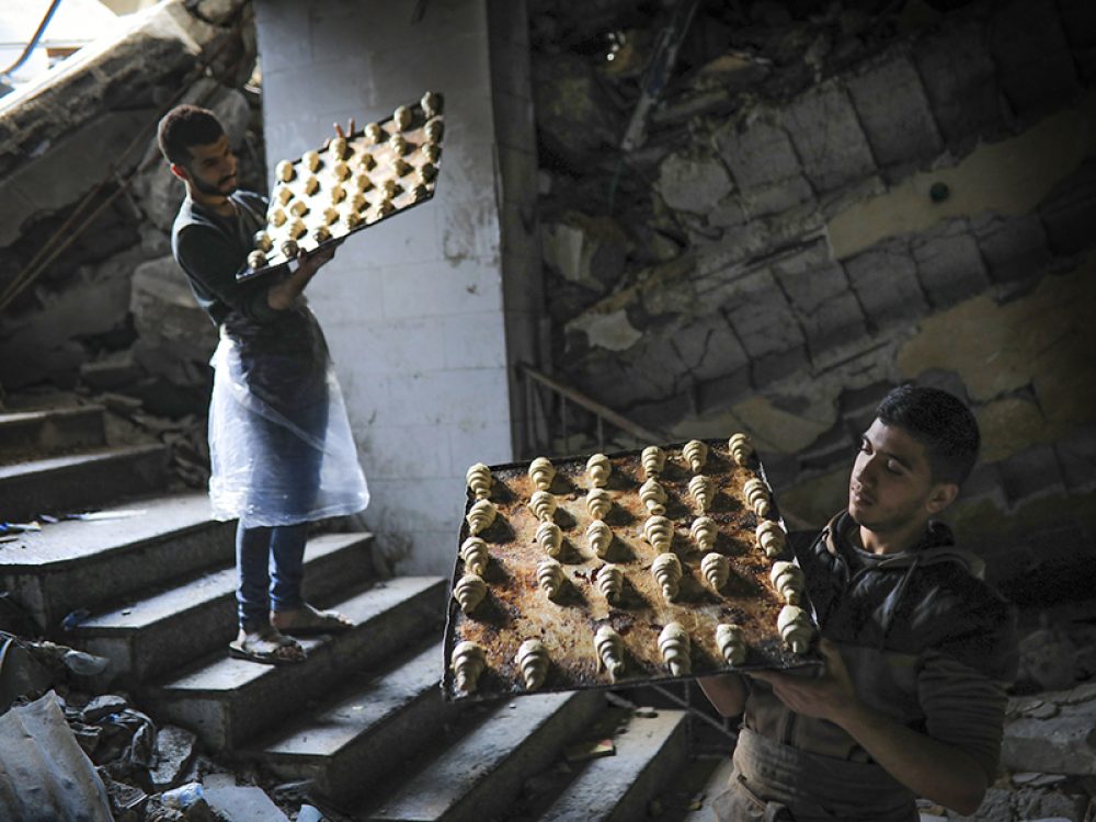 Palestijnen aan het werk in een beschadigde bakkerij in Gaza. Foto: Ali Hassan/Flash90