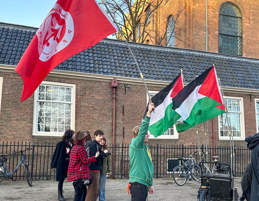 Een demonstrant zwaait met de vlag van de PFLP bij de Portugese Synagoge in Amsterdam. Foto: Esther Voet