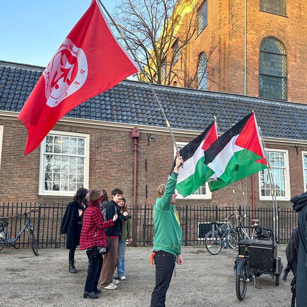 Een demonstrant zwaait met de vlag van de PFLP bij de Portugese Synagoge in Amsterdam. Foto: Esther Voet