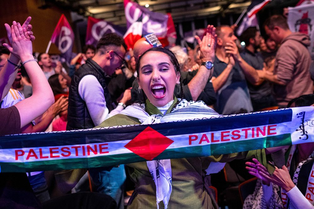 A woman with a Palestinian flag in reference to the war between Israel and Hamas in Gaza in Palestine during a campaign meeting for the European elect